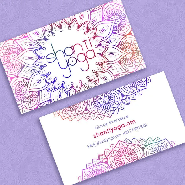 Two Shanti Yoga business cards on a lilac ground. The front is filled edge to edge with a fine-line mandala in pink, purple and orange with the lowercase wordmark at its centre; the back is white, with a rule of mandala petals top and bottom and contact details in pink and purple.