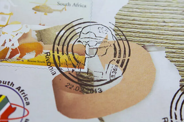 Macro detail of a circular Pretoria cancellation printed across the stamp and the envelope, its engraved globe overlapping a torn paper arrow.